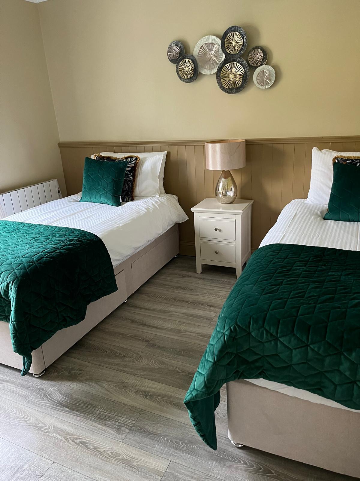 Twin bedroom made up with fresh linen for arriving guests